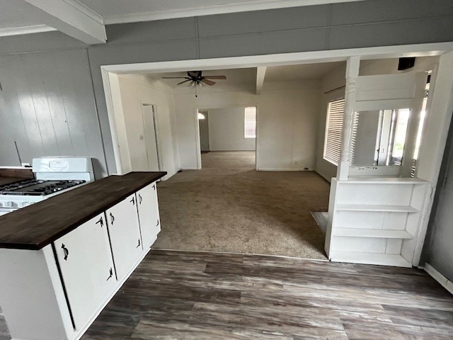 kitchen featuring white cabinets, ceiling fan, dark colored carpet, and beam ceiling