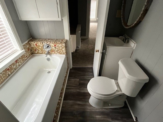 bathroom with hardwood / wood-style floors, toilet, sink, and a bathtub