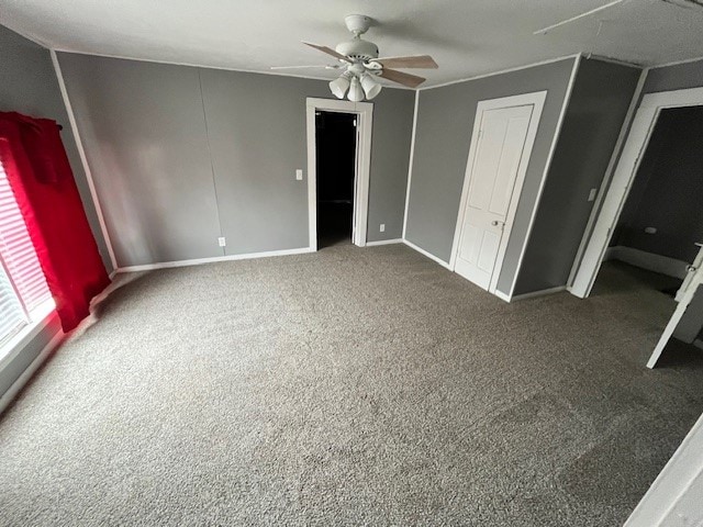 unfurnished bedroom featuring ceiling fan and dark colored carpet