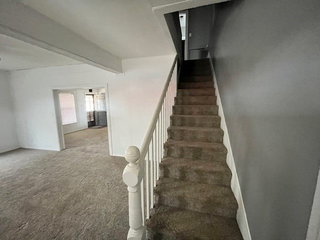 staircase with carpet flooring and beamed ceiling