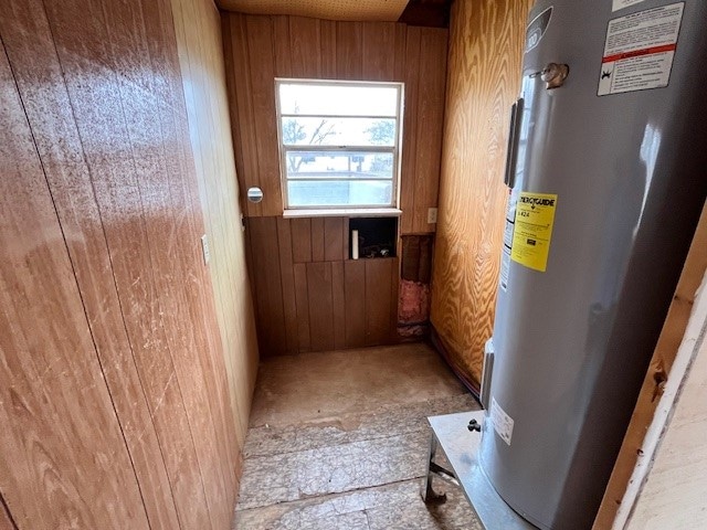 interior space featuring water heater and wooden walls