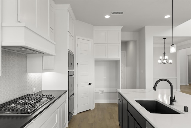 kitchen with pendant lighting, white cabinets, sink, and stainless steel gas cooktop