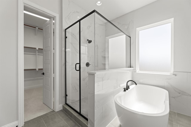 bathroom featuring tile patterned floors, tile walls, and independent shower and bath