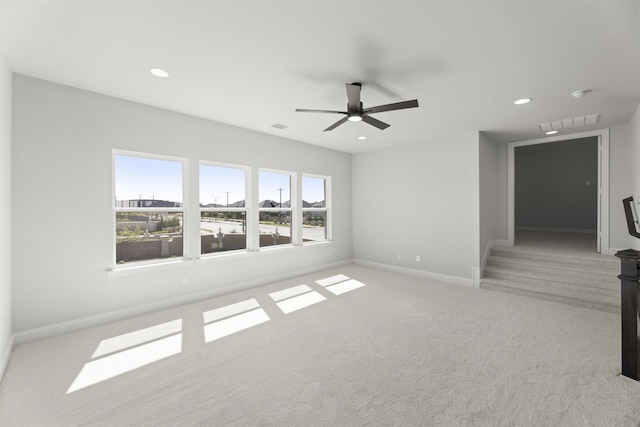 unfurnished living room featuring light colored carpet and ceiling fan