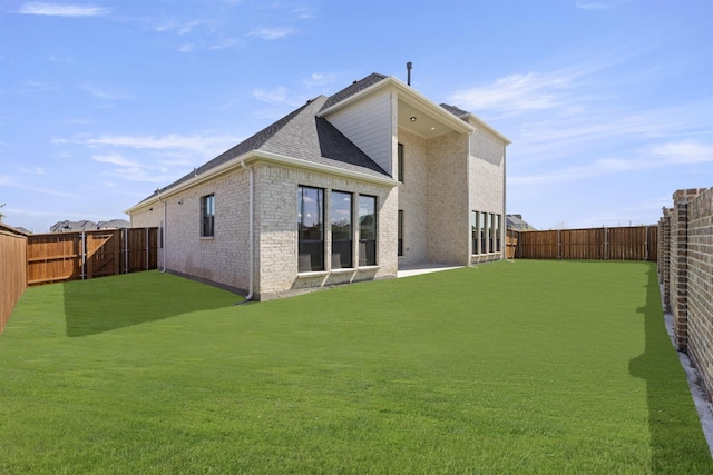 rear view of house featuring a yard