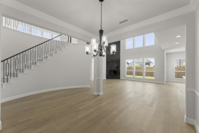 interior space featuring a wealth of natural light, hardwood / wood-style floors, a high end fireplace, and crown molding