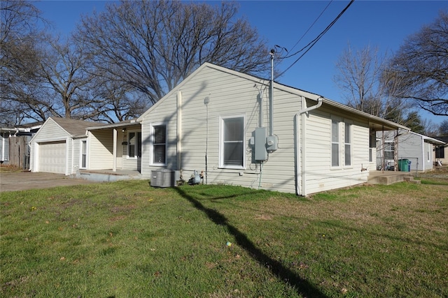 view of front of property with central AC unit, a front yard, and a garage