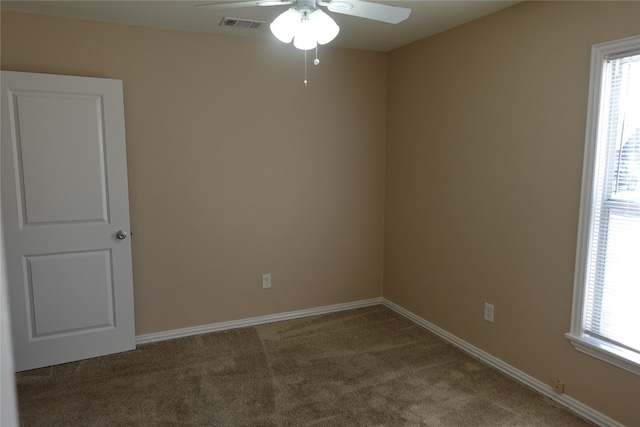 empty room featuring dark colored carpet and ceiling fan