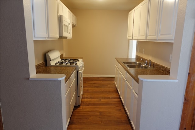 kitchen featuring white appliances, white cabinets, dark hardwood / wood-style floors, and sink