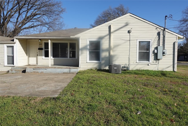 exterior space featuring a front lawn, a patio area, and central AC unit