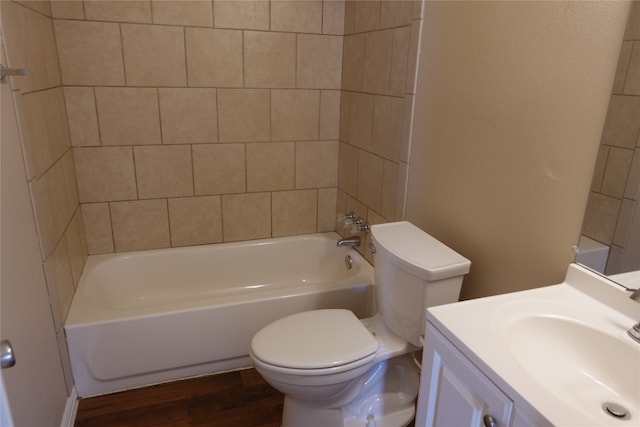 full bathroom featuring toilet, hardwood / wood-style floors, tiled shower / bath combo, and vanity