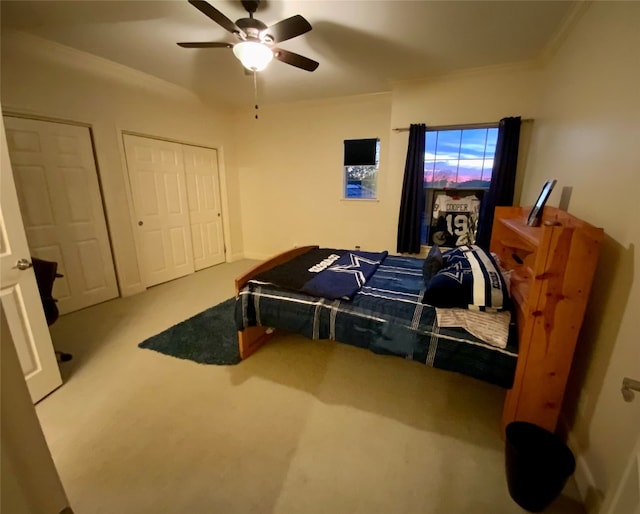 carpeted bedroom featuring crown molding and ceiling fan