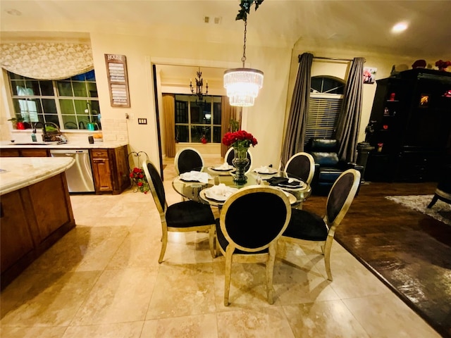 dining room with sink, light tile floors, and a chandelier