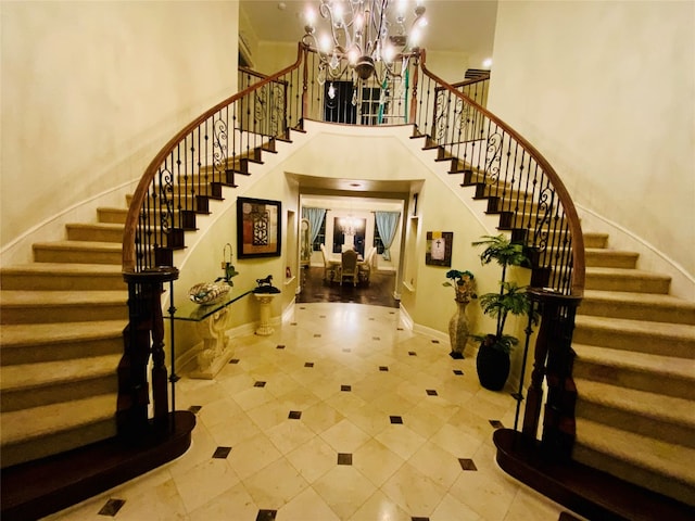 tiled entryway with a chandelier and a high ceiling