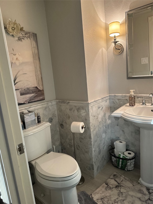 bathroom with sink, toilet, and tile flooring