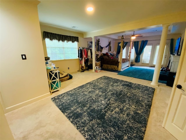 carpeted bedroom featuring multiple windows and decorative columns