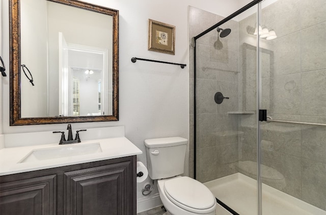 bathroom featuring an enclosed shower, toilet, and large vanity