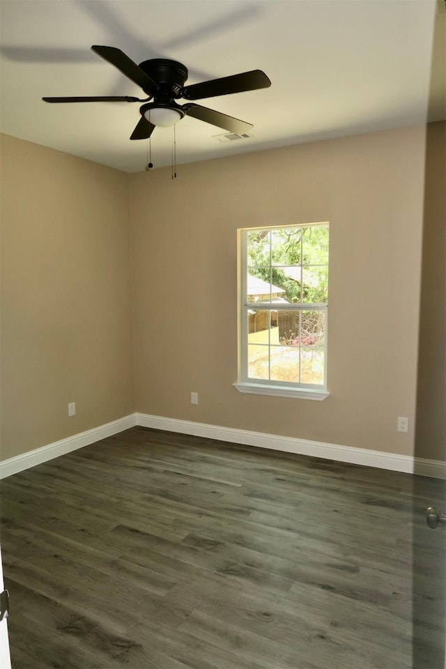 empty room featuring dark wood-style floors, baseboards, and a ceiling fan