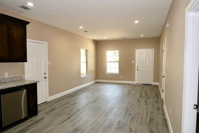 kitchen featuring light stone countertops, light wood-type flooring, dark brown cabinetry, and dishwasher