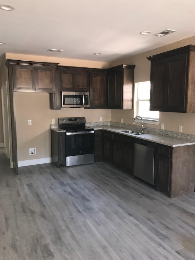 kitchen featuring light wood-type flooring, visible vents, stainless steel appliances, and a sink