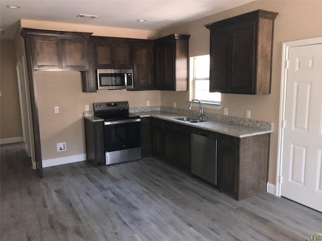 kitchen featuring stainless steel appliances, light wood-type flooring, visible vents, and a sink