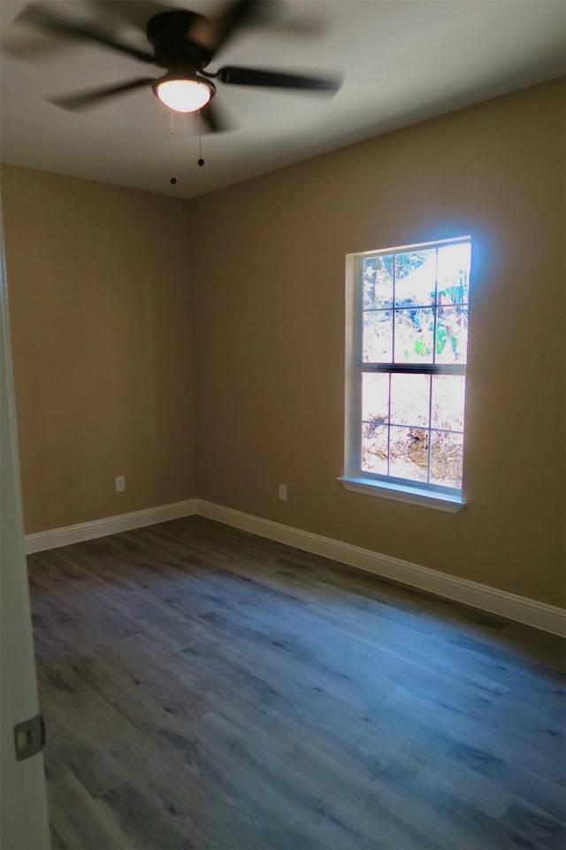 spare room with ceiling fan, baseboards, and wood finished floors