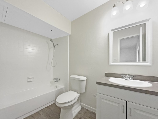 full bathroom featuring tiled shower / bath, toilet, large vanity, and wood-type flooring