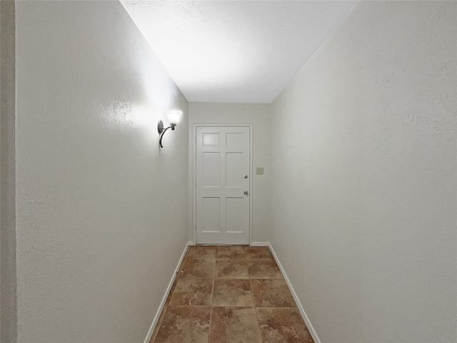 corridor featuring dark tile flooring