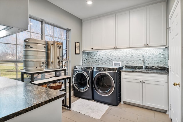 laundry area with cabinets, sink, separate washer and dryer, and light tile patterned floors