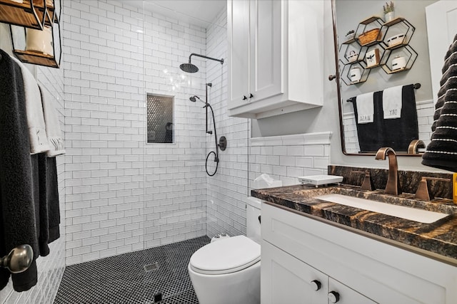 bathroom featuring vanity, toilet, and tiled shower