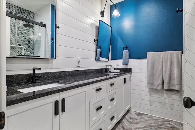 bathroom with vanity, walk in shower, and tile walls