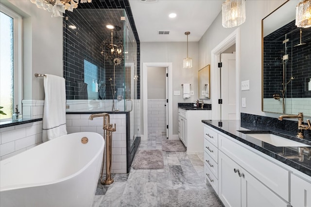 bathroom with vanity and separate shower and tub