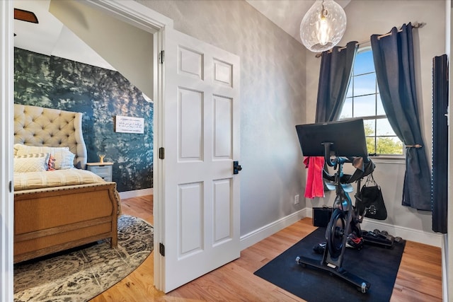 exercise room with vaulted ceiling and hardwood / wood-style flooring