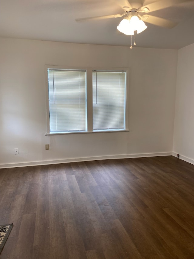 empty room with ceiling fan and dark hardwood / wood-style floors