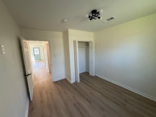 unfurnished bedroom with a closet and dark hardwood / wood-style flooring