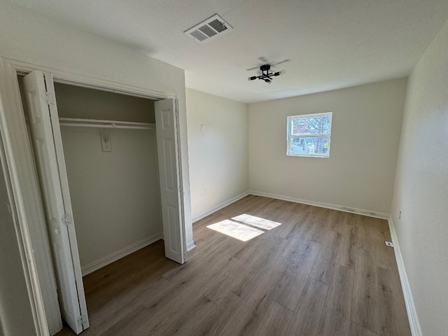 unfurnished bedroom featuring a closet and light hardwood / wood-style flooring