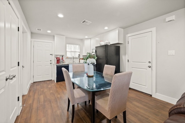 dining space featuring hardwood / wood-style floors and sink