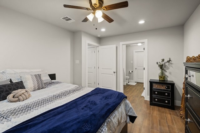 bedroom featuring connected bathroom, dark hardwood / wood-style floors, and ceiling fan