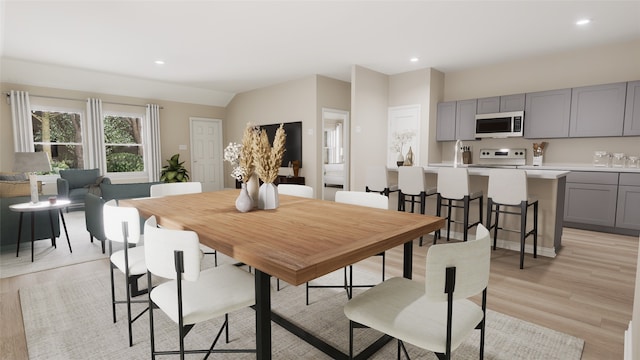 dining space with light hardwood / wood-style floors and sink