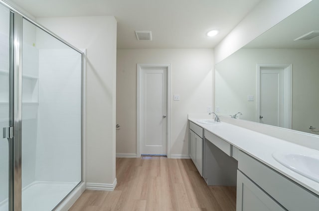 bathroom featuring an enclosed shower, vanity, and wood-type flooring