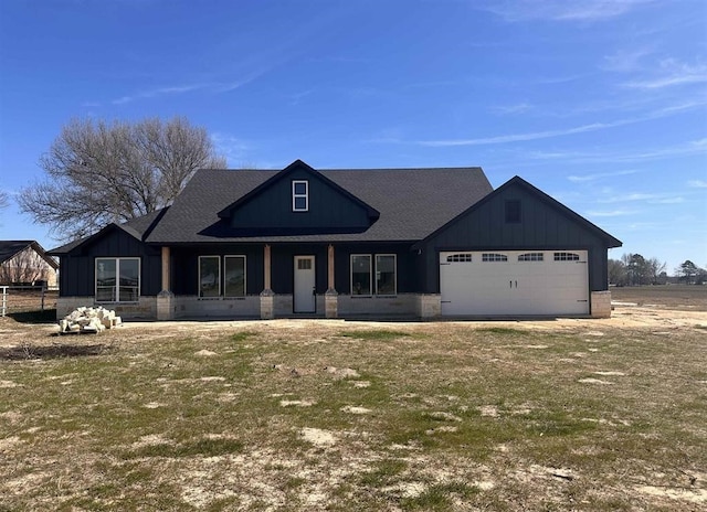 view of front facade with covered porch, a front lawn, and a garage