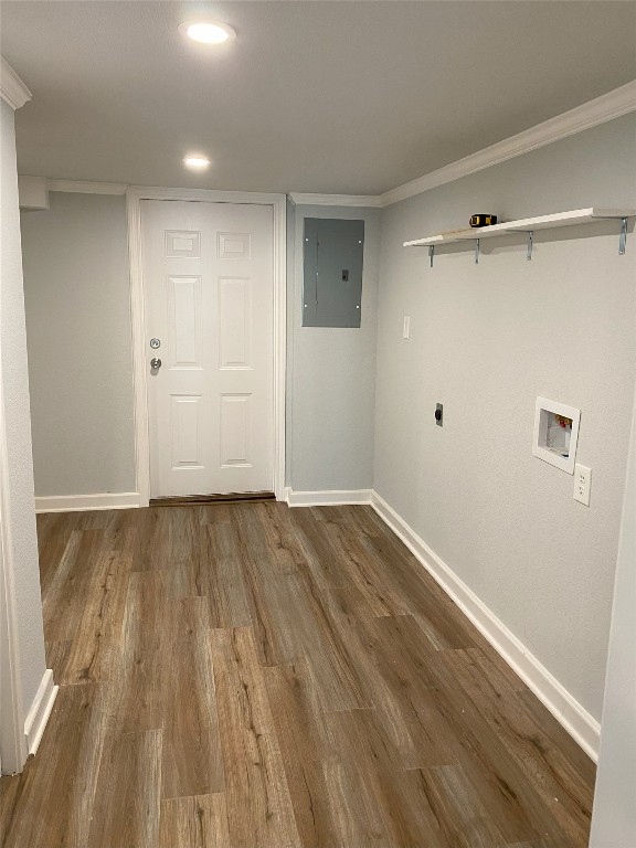 clothes washing area featuring electric panel, baseboards, wood finished floors, crown molding, and washer hookup