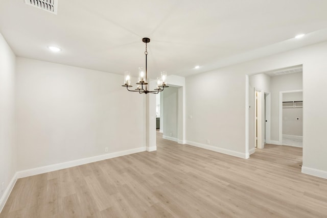 unfurnished dining area featuring a notable chandelier and light hardwood / wood-style floors