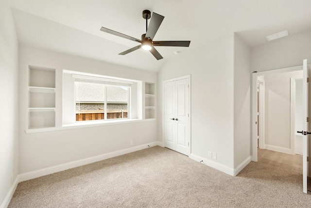 unfurnished bedroom with ceiling fan, a closet, light carpet, and lofted ceiling