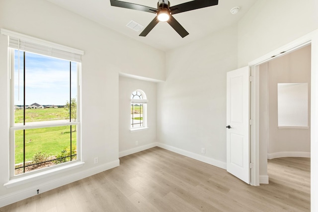 unfurnished room featuring light hardwood / wood-style flooring, a wealth of natural light, and ceiling fan