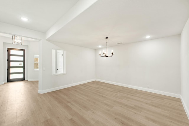 entrance foyer with light hardwood / wood-style flooring and a notable chandelier