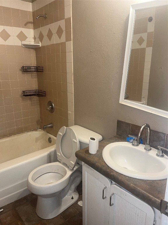 full bathroom featuring vanity, tile floors, toilet, and tiled shower / bath