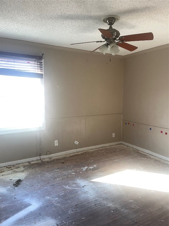 spare room with ceiling fan, a textured ceiling, and wood-type flooring