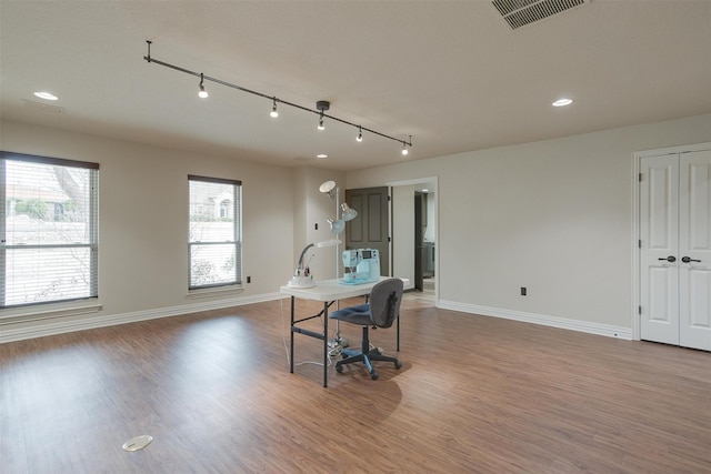 dining space featuring rail lighting and hardwood / wood-style floors