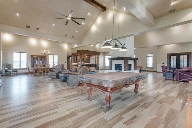 playroom with beamed ceiling, a fireplace, ceiling fan with notable chandelier, high vaulted ceiling, and billiards